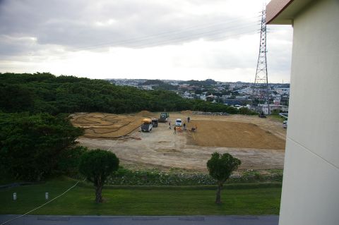 1986 Ford Bronco - A construction site is active with several vehicles and a dirt track, with a town visible in the background.