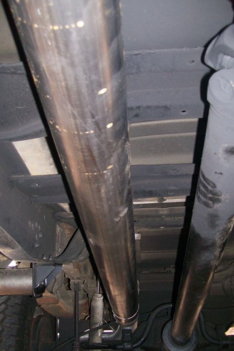 1992 Ford C-350 (Centurion Conversions) - The underside of a vehicle is visible, focusing on the exhaust system and drivetrain components.