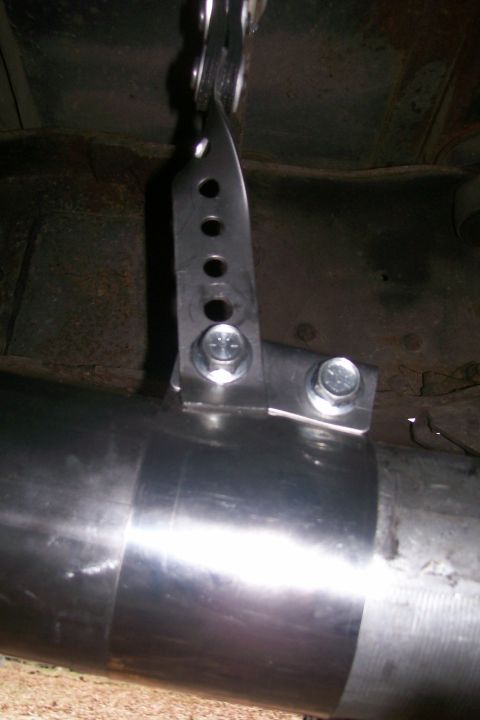 1992 Ford C-350 (Centurion Conversions) - Close-up of a custom-fabricated exhaust hanger bracket attached to a vehicle's exhaust pipe.
