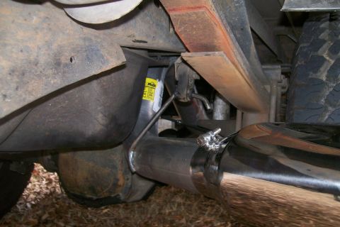 1992 Ford C-350 (Centurion Conversions) - Underside view of a vehicle's exhaust system, showing a new pipe and suspension components.