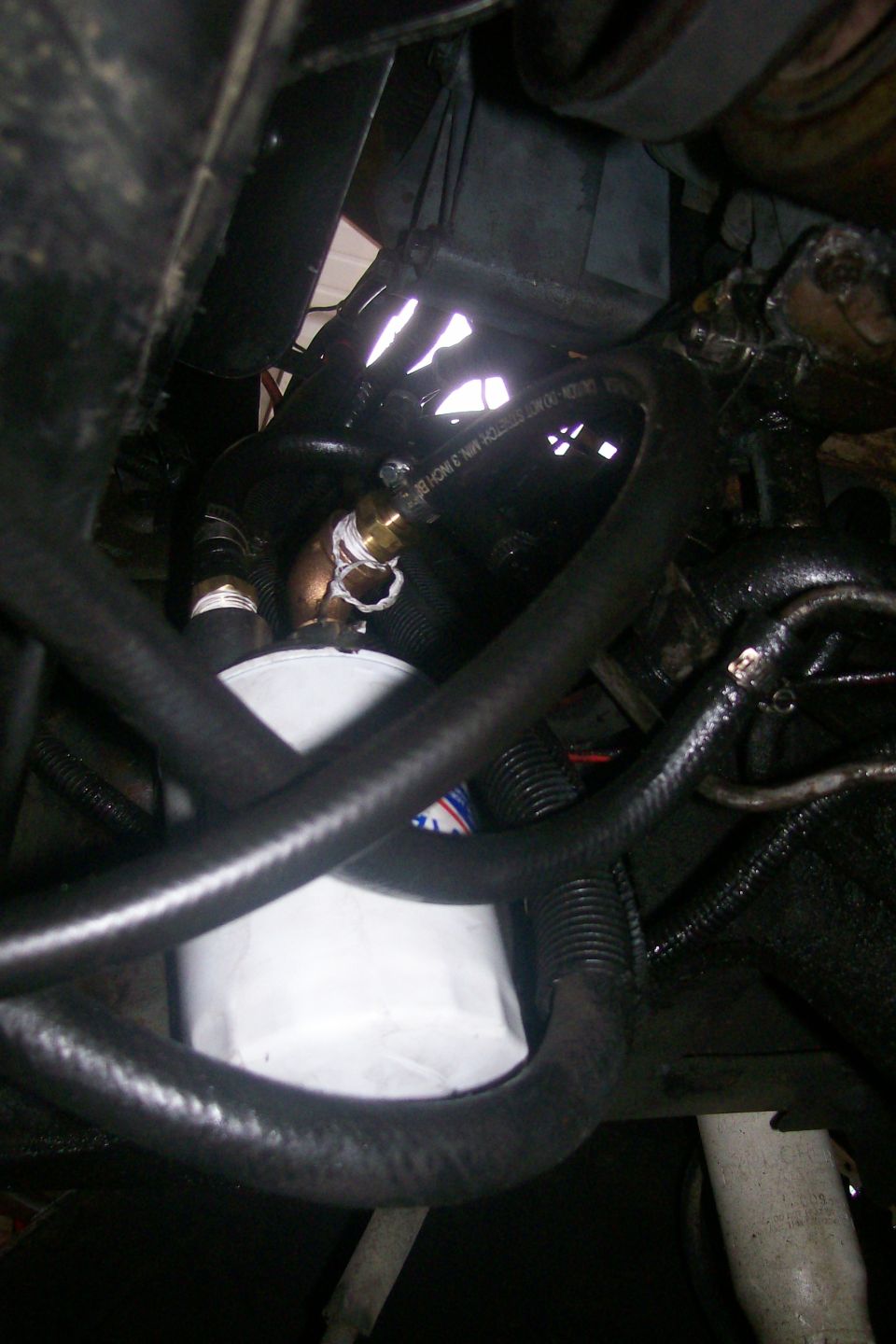 Engine oil filter with black hoses and brass fittings