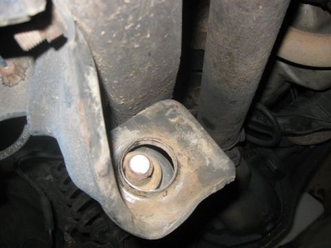 1992 Ford Bronco - Close-up of a vehicle's suspension mounting bracket, showing a bolt and surrounding components.