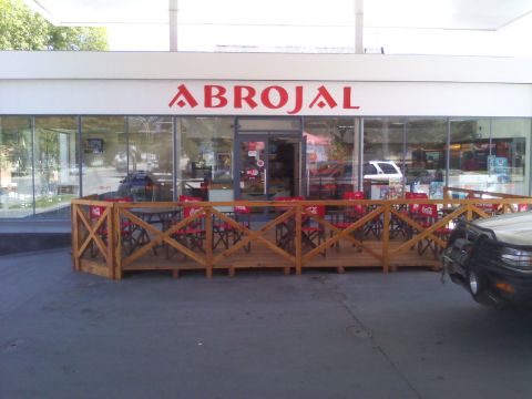 1986 Ford Bronco - A gas station with a branded sign and an outdoor seating area is visible, with a vehicle parked in the foreground.