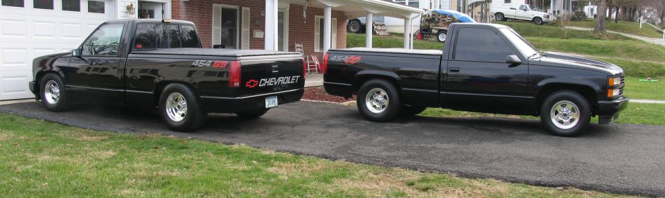 Two black lowered Chevrolet 454 SS pickups parked on a driveway