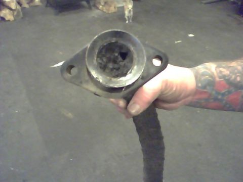 1997 Dodge 2500 - A hand holds an exhaust pipe flange with a braided hose attached. The Supermotors.net logo is visible in the lower right corner.