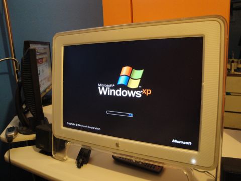 1993 Ford Taurus - A computer setup two monitors, with one displaying the Microsoft Windows XP operating system loading screen.