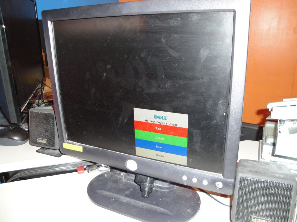 Dell monitor showing self-test screen with red, green, blue, and white blocks