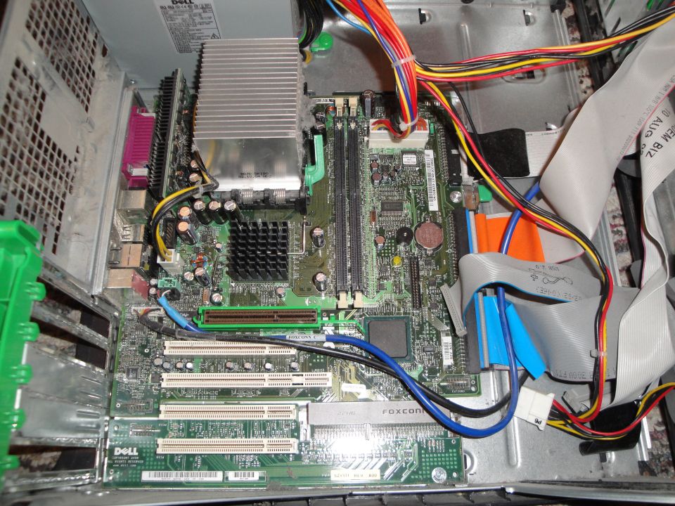 Inside of a Dell computer tower showing motherboard, power supply, and cables