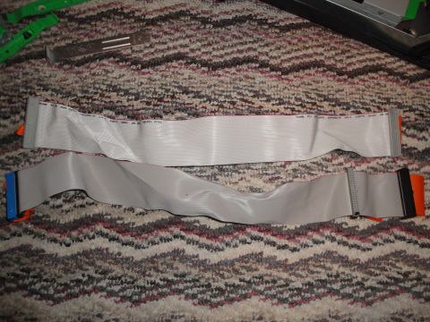 1993 Ford Taurus - Two IDE ribbon cables, one with orange connectors and the other with blue and orange connectors, are laid out on a patterned carpet.