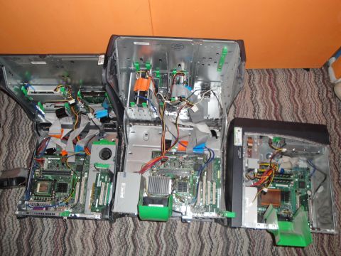 1993 Ford Taurus - Multiple computer towers are disassembled, revealing their internal circuitry and wiring on a patterned carpet.