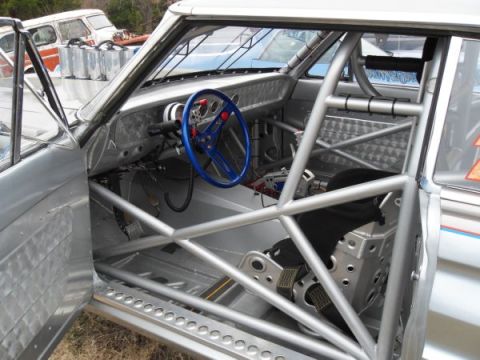 1963 Ford Fairlane - Custom racing interior features a full roll cage and racing seat, with a van visible outside.