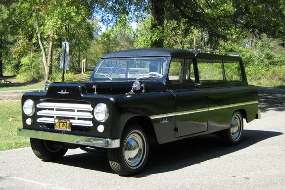 Black vintage carryall station wagon from the 3/4 front on a paved lot