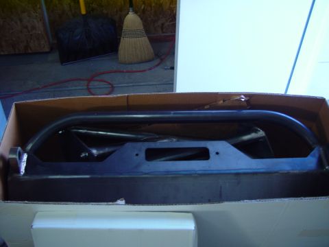 1993 Ford Bronco - Aftermarket front bumper with a cutout for a winch, packaged in a cardboard box.