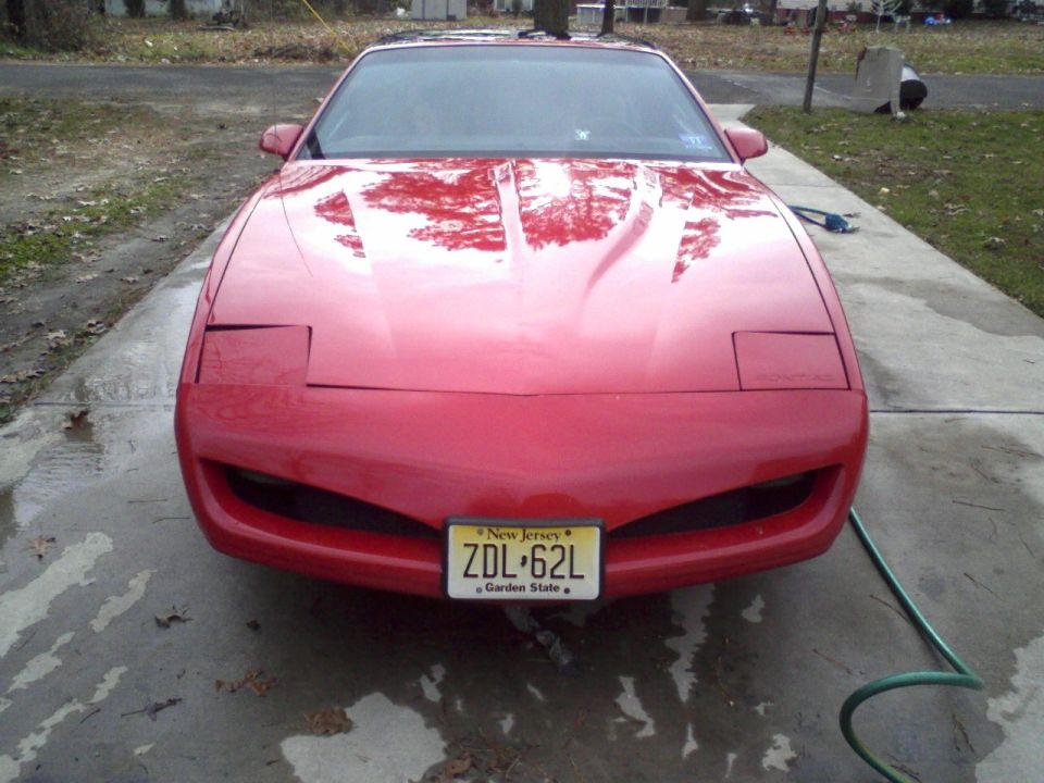 Red Pontiac Firebird coupe, front view, on driveway with NJ plate