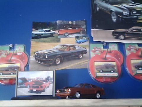 1978 Ford Mustang II - A 1977 Ford Mustang II is displayed alongside other car memorabilia and toy models.