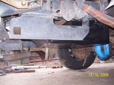 1978 Ford Bronco - Close-up of vehicle undercarriage components, including fuel tank and suspension parts of the rear axle.