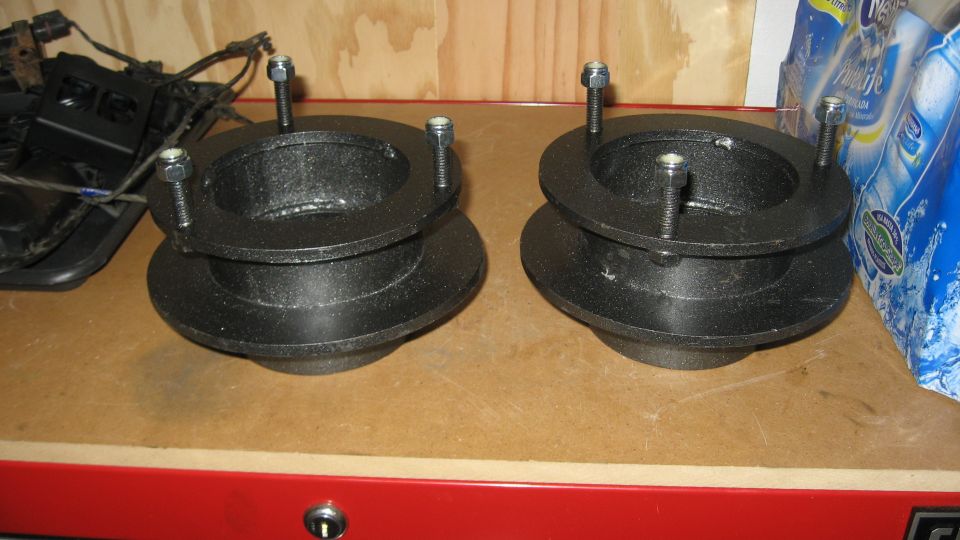 pair of black metal suspension lift spacers with bolts