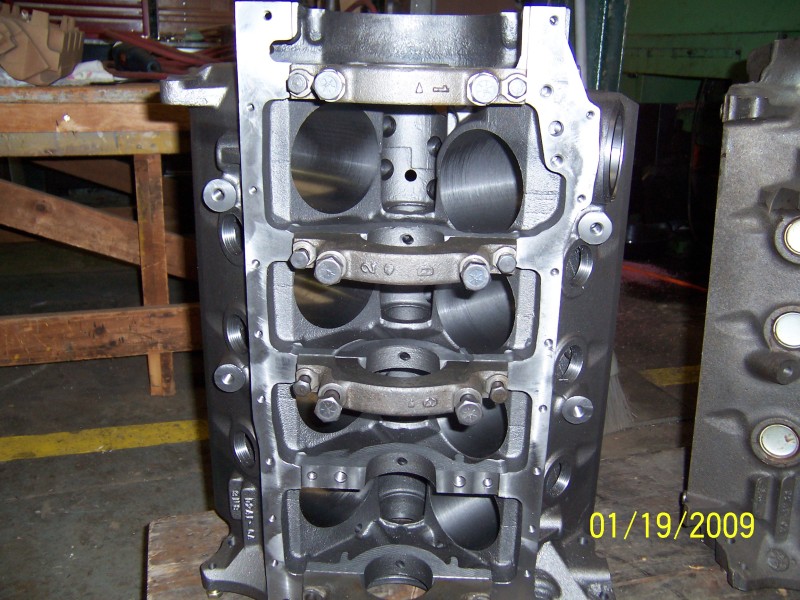 Bare V8 block viewed from below showing honed bores and numbered main bearing caps