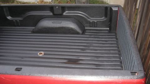 1997 Dodge 2500 - The interior of a 1997 Dodge 2500 truck bed, showing the spray-in liner and tie-down points.