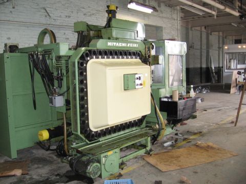1972 Ford Ranchero - A large green Hitachi Seiki CNC machining center with a chain-style automatic tool changer holding rows of tool holders, installed on the c…