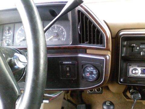 1990 Ford Bronco - The interior of a 1990 Ford Bronco displays its dashboard, complete with gauges and an overdrive switch.