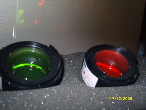 1989 Ford Bronco - Close-up view of two automotive lights, one green and one red, with visible text on the red light's housing.