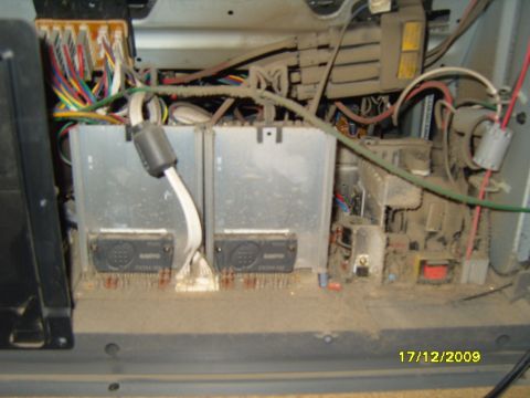 1989 Ford Bronco - Close-up view of dusty interior electronics, Sanyo components and a complex wiring harness.