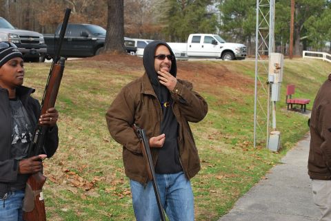 1979 Ford F-150 - Three individuals, two holding shotguns, are gathered outdoors with several trucks visible in the background.