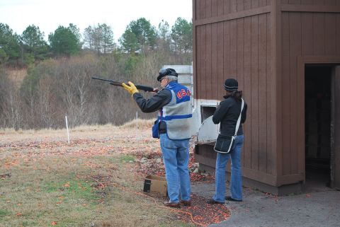1979 Ford F-150 - Two people at a clay shooting range, with a wooden structure in the background.