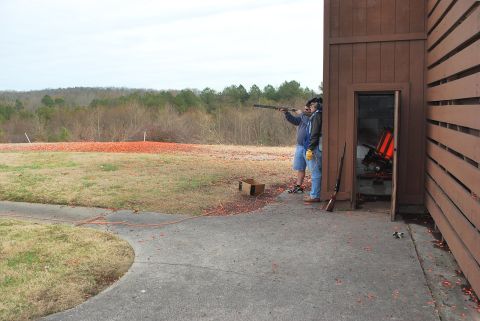 1979 Ford F-150 - Two men participate in clay shooting at an outdoor range, with one man taking aim and the other observing.