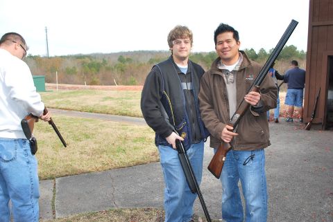 1979 Ford F-150 - People gathered at an outdoor shooting range, holding firearms and preparing for an activity.