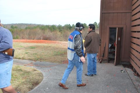 1979 Ford F-150 - Men gather at a shooting range, with a building and wooded area in the background.