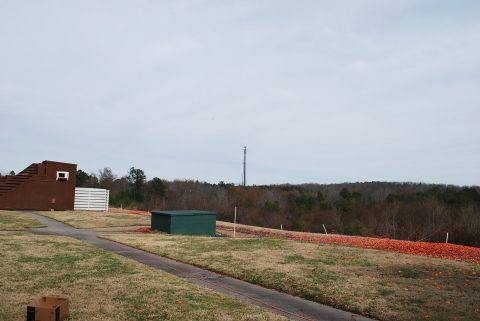 1979 Ford F-150 - A view of an outdoor shooting range with a wooded area in the background under a cloudy sky.