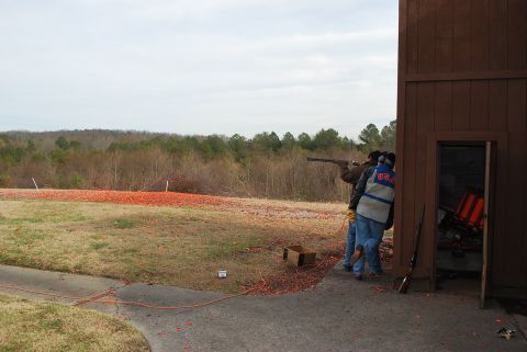 1979 Ford F-150 - A shooting range scene with participants and a wooden shelter, under an overcast sky.