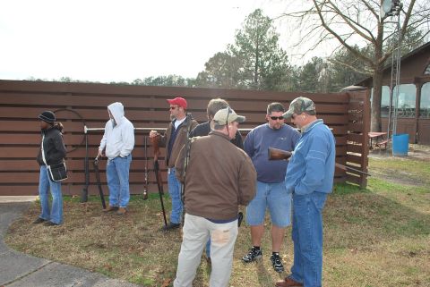 1979 Ford F-150 - A group of men are standing around outdoors, some holding shotguns, near a shooting range facility.