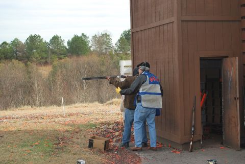 1979 Ford F-150 - Participants practice trap shooting at an outdoor range with a wooden shelter nearby.