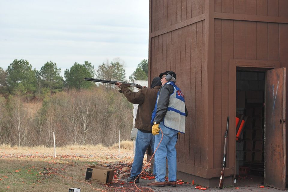 Two men practice shooting at a clay pigeon range