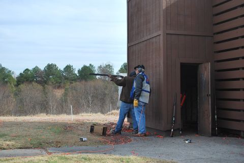 1979 Ford F-150 - Clay pigeon shooting event with participants and a range structure.