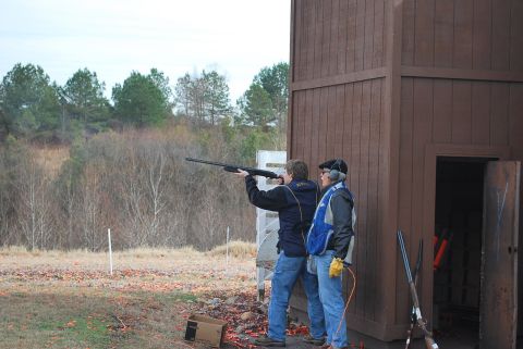 1979 Ford F-150 - Two individuals participate in a clay pigeon shooting activity at an outdoor range.