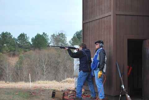 1979 Ford F-150 - Two men participate in a clay pigeon shooting event at an outdoor range.