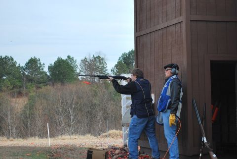 1979 Ford F-150 - Two men participate in a clay pigeon shooting event at an outdoor range.