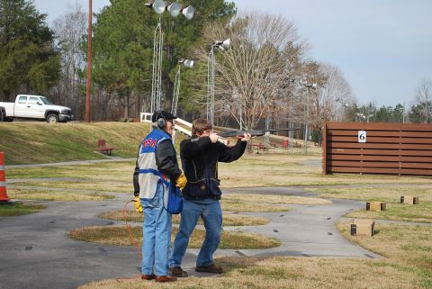 1979 Ford F-150 - Two people are at a trap shooting range, one is aiming a shotgun.
