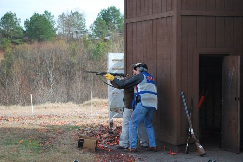 1979 Ford F-150 - Two men are at a shooting range, one instructing the other on how to aim a shotgun.