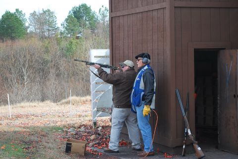 1979 Ford F-150 - Men practice shooting at a clay pigeon range, with two shotguns leaning against a wooden structure.