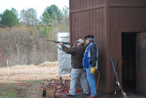 1979 Ford F-150 - Two men participate in a shooting event at an outdoor range, with one man taking aim and the other observing.
