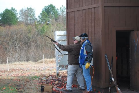 1979 Ford F-150 - Men practice skeet shooting with shotguns at an outdoor range.