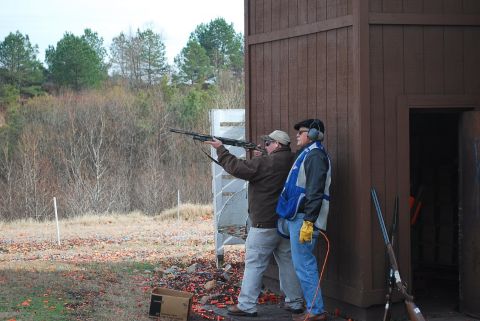 1979 Ford F-150 - Men practice shooting at a clay pigeon range with shotguns.