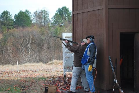 1979 Ford F-150 - Clay pigeon shooting event with participants aiming their shotguns.