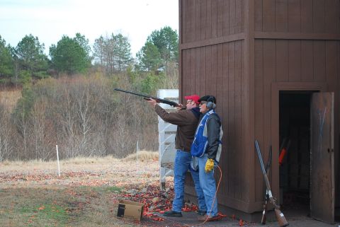 1979 Ford F-150 - Clay shooting practice session with two participants and a wooden structure.