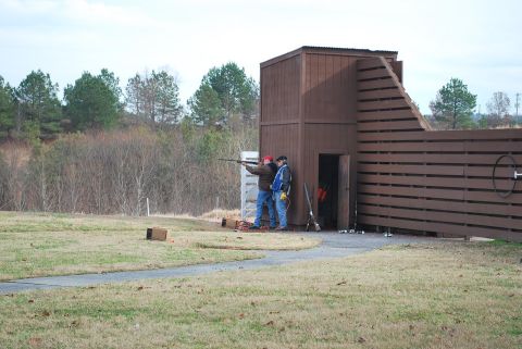 1979 Ford F-150 - Clay shooting range with two participants and a wooden structure.